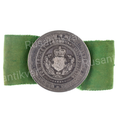 Медаль (брошь для женщин) Императорского Финляндского Общества сельского хозяйства, на ленте зеленого цвета.